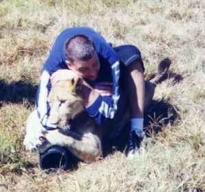 Matt chokes a lion in Africa.